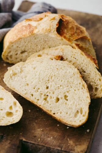 This amazing artisan no-knead bread recipe will make you feel like a rock-star baker! It has a perfectly crispy crust with a soft and chewy texture on the inside. Plus, it couldn't be easier to make from home! No knead bread cut into slices.