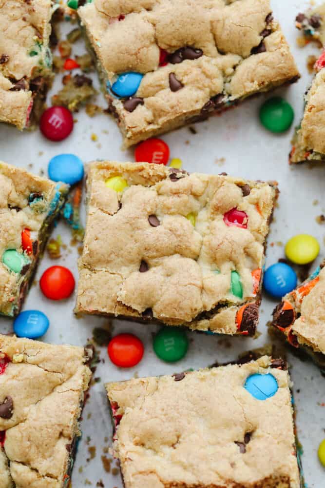 M&M cookie bars are everything you love about cookies and candy in one! Golden, buttery, and ready to feed a crowd, this is the dessert recipe your family will not be able to get enough of! Cut M&M bars sprinkled with candy.
