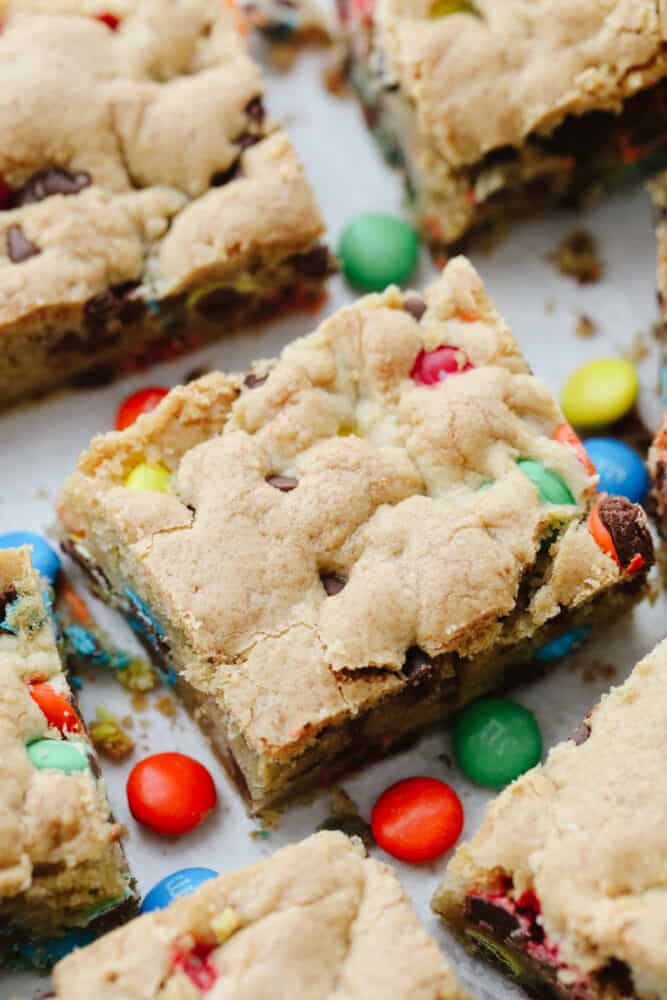 M&M cookie bars are everything you love about blondies and candy in one! Golden, buttery, and ready to feed a crowd, this is the dessert recipe your family will not be able to get enough of! Close-up of a M&M cookie bar.