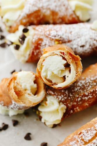 Crispy and creamy, this ricotta-filled dessert is as decadent as it gets! Cannolis are the traditional Italian treats you’ll want to make again and again. Closeup of a cannoli broken in half.