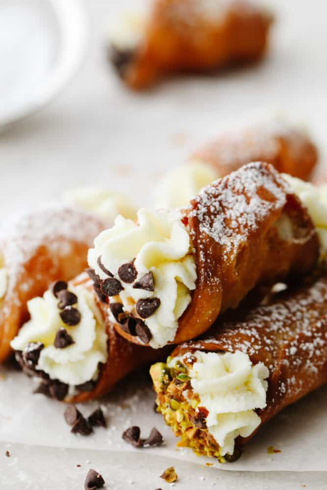 Crispy and creamy, this ricotta-filled dessert is as decadent as it gets! Cannolis are the traditional Italian treats you’ll want to make again and again. Closeup of 3 cannolis.