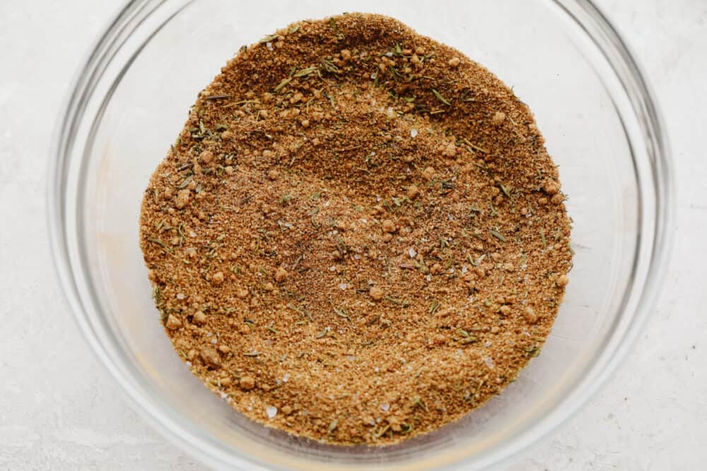 Jerk seasoning is the most deliciously sweet and savory blend of spices! It's simple to use and even more easy to make! You will have yourself a custom homemade seasoning in less than 5 minutes! Jerk seasoning all mixed up in a glass bowl.