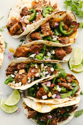 Beef brisket tacos are full of delicious flavor and topped with perfectly tender and juicy meat. This is a meal that your entire family will go crazy over! Beef brisket tacos with toppings in a tortilla.