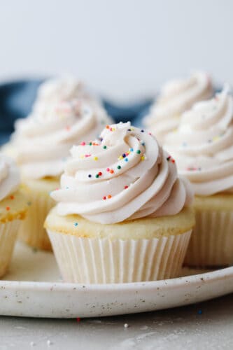 White cupcakes are light, fluffy and perfectly moist! Swirled with delicious white frosting and topped with sprinkles, these cupcakes are to die for! White cupcakes with frosting and sprinkles.