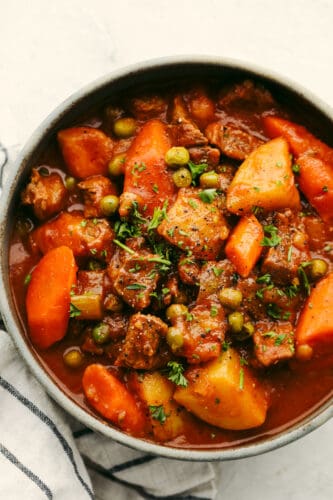 Instant Pot Beef Stew is perfect for those cool fall nights, and great when you want to whip up cozy beef stew in under an hour! Sauté the beef in the bottom of the instant pot, throw in your veggies and broth, turn it on and call it a day! Beef stew garnished and in a bowl.