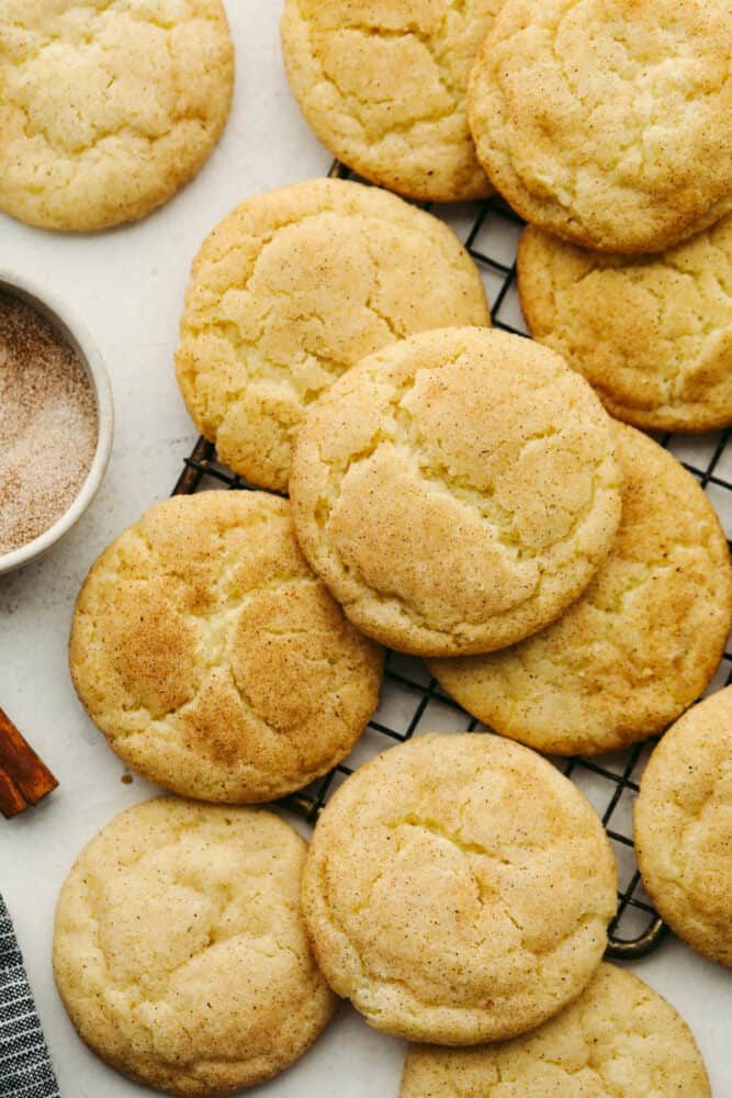 These snickerdoodle are delightfully soft and full of delicious cinnamon flavor! They are SOO GOOD and you won't be able to stop at just one! Snickerdoodles on a cooling rack.