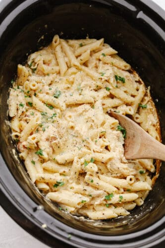 This Olive Garden crockpot chicken is to die for! The juicy and tender chicken cooked with some pasta is insanely delicious! Plus, it's super easy which is a total win-win! Chicken and pasta cooked in a crockpot.