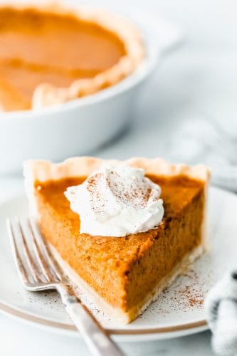 Grandma's famous pumpkin pie is smooth, thick, and creamy! A MUST for the holidays and the best when served with a big scoop of whipped cream on top! A slice of pumpkin pie with whipped cream
