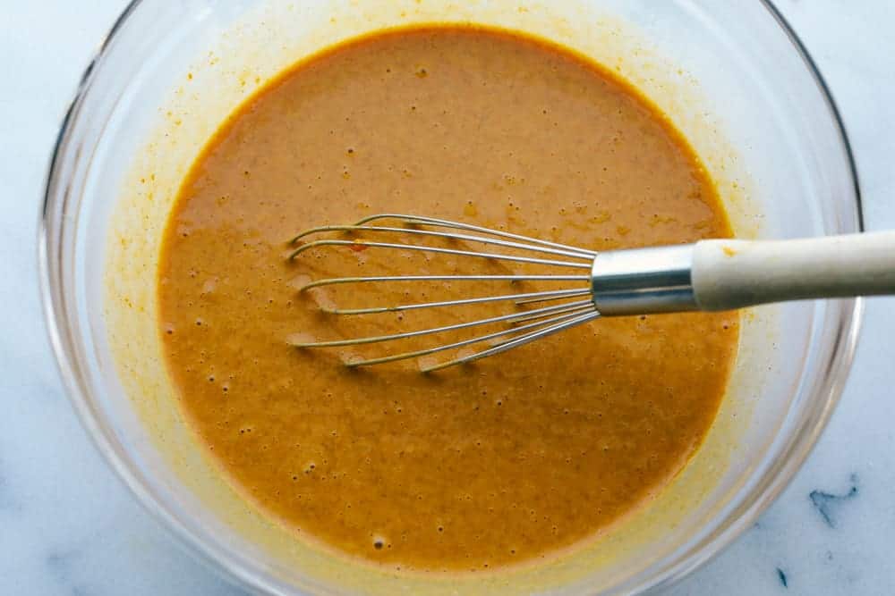 Grandma's famous pumpkin pie is smooth, thick, and creamy! A MUST for the holidays and the best when served with a big scoop of whipped cream on top! A bowl being mixed with pie filling.