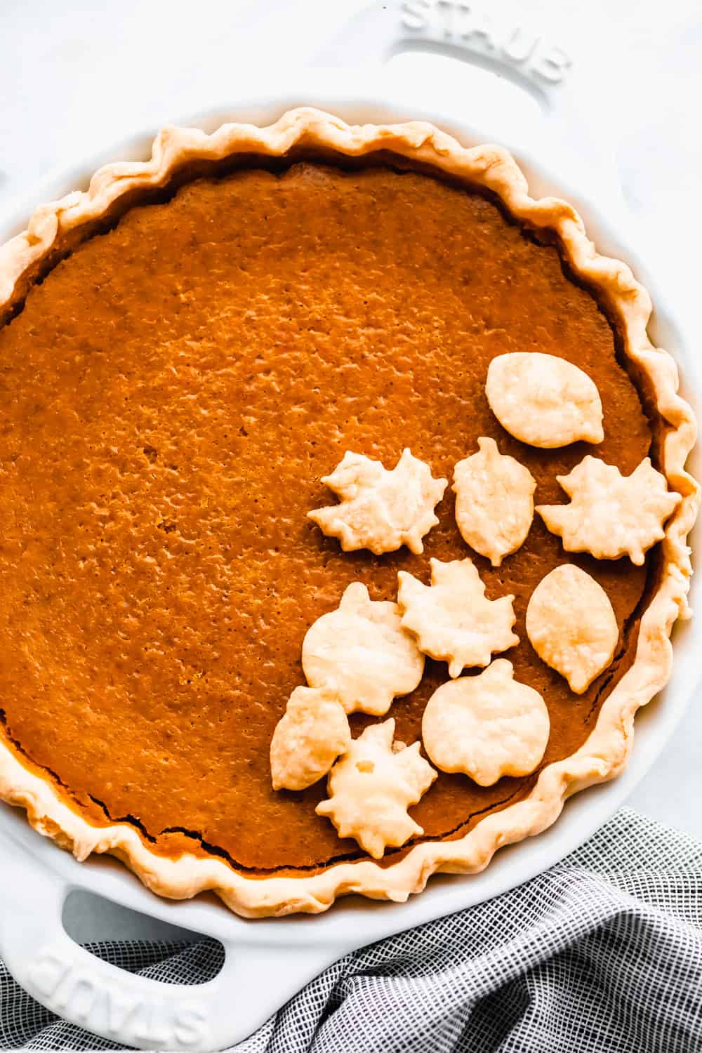Grandma's famous pumpkin pie is smooth, thick, and creamy! A MUST for the holidays and the best when served with a big scoop of whipped cream on top! Baked pumpkin pie with decorative pie crust leaves