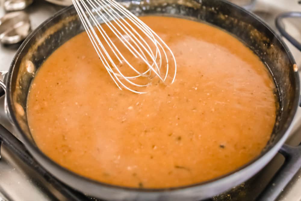 Turkey gravy is rich, thick, and creamy! This gravy takes less than 15 minutes to make! Once you drizzle it all over your turkey and potatoes, well, you will use this recipe for every holiday season! Stirring the turkey gravy in a sauce pan with a whisk.
