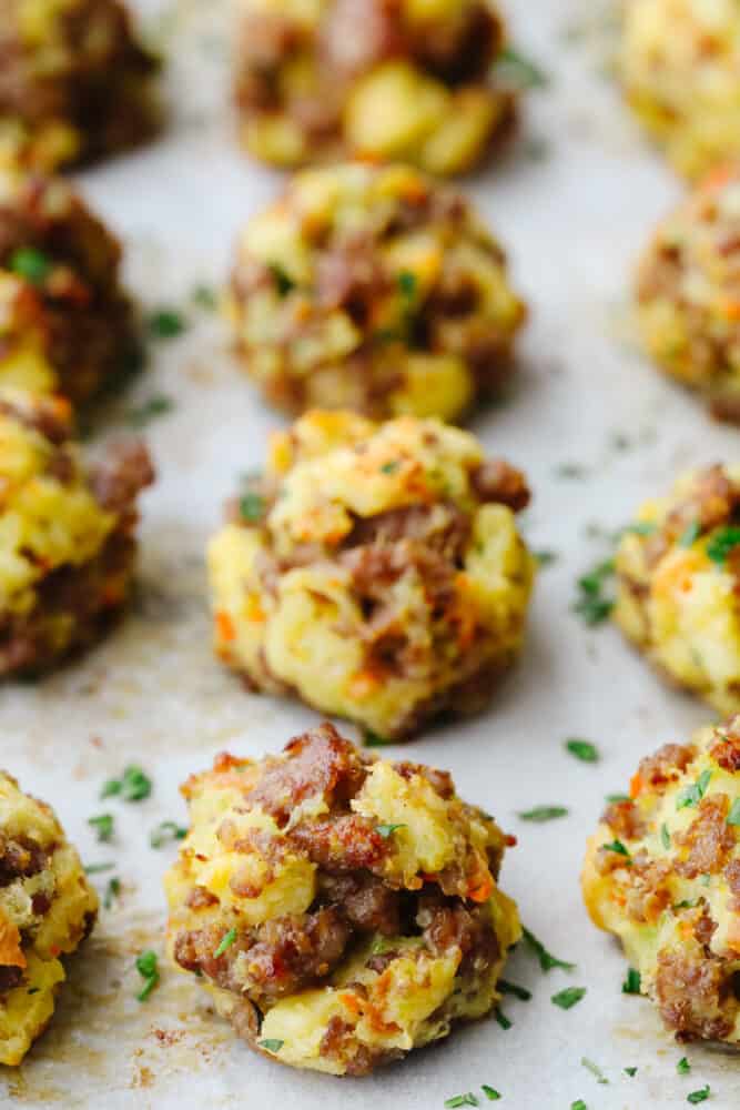 Sausage stuffing balls are the perfect appetizer or side dish for any holiday meal! These are full of such delicious flavors, you won't be able to stop at just one! Sausage stuffing balls on a baking sheet ready to eat.