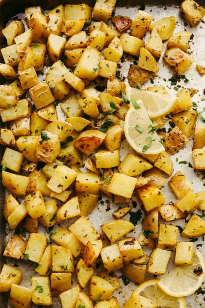 Roasted lemon potatoes are the perfect side dish for any of your meals! They have the best fresh taste that is SOO GOOD! Your friends and family will love them! Cubed potatoes seasoned on a baking sheet.