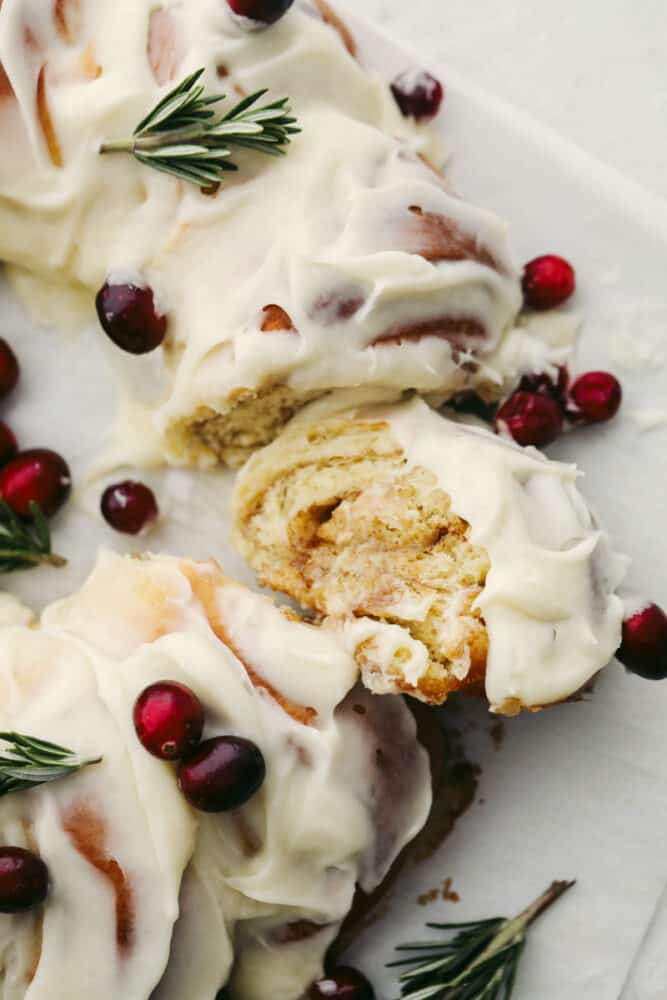 The holiday season doesn't get much more festive at the dinner table than with this cinnamon roll wreath! It's beautiful and delicious which makes it the perfect choice for your holiday breakfast, brunch, or dessert! The top view of a cinnamon roll wreath that is sliced.