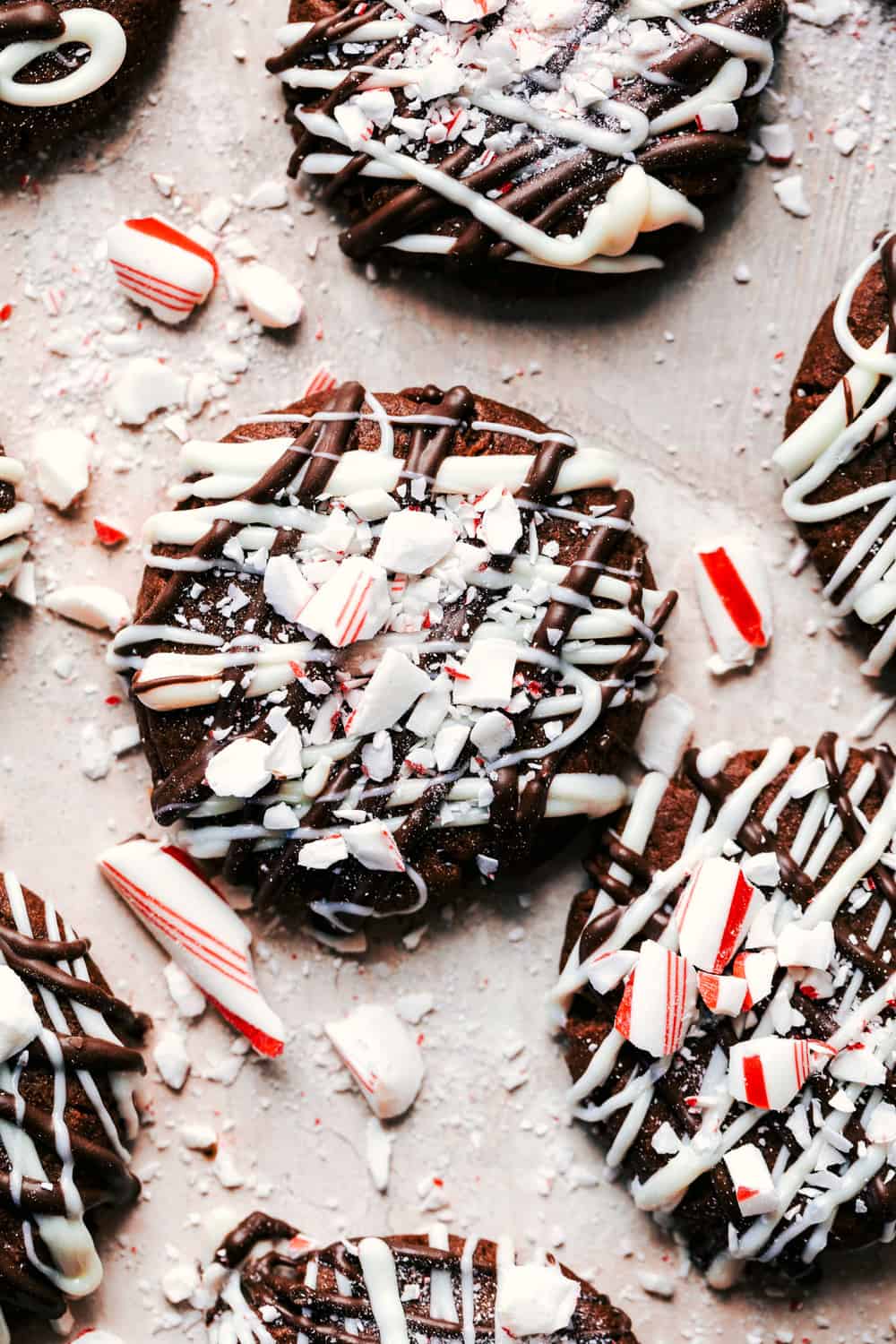 Triple chocolate peppermint cookies are soft and chewy cookies that get drizzled with white and dark chocolate. They are topped with crushed candy canes and are the perfect treat for the holidays! Triple Chocolate Peppermint Cookies close up.
