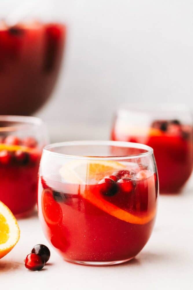 This easy Christmas punch is delicious and so festive! It's the perfect punch to serve at your next gathering. It's for all ages, young and old! A glass filled with Christmas punch.