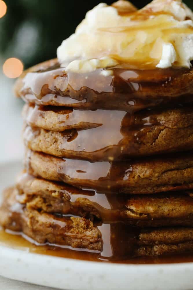 This homemade caramel syrup is the best that you will ever taste! Not only does it have the perfect texture but it is made for drizzling on any and all of your favorite breakfast foods! A stack of homemade pancakes drizzled with caramel syrup.