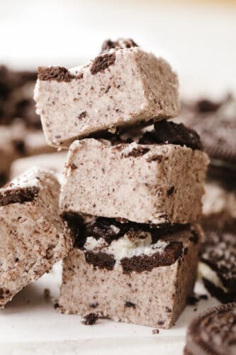 Fudge is a classic holiday treat and these cookies and cream flavor really takes it to the next level. Creamy, Oreo fudge just cannot be beat! A stack of cookies and cream fudge squares.