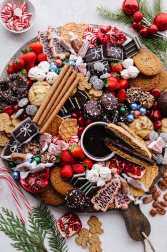 If you are looking for a Christmas dessert to impress your guests then this charcuterie board is it! Stunning and delicious, this board is full of candy, chocolate, cookies, and fruit for the holiday season! A Christmas dessert charcuterie board.