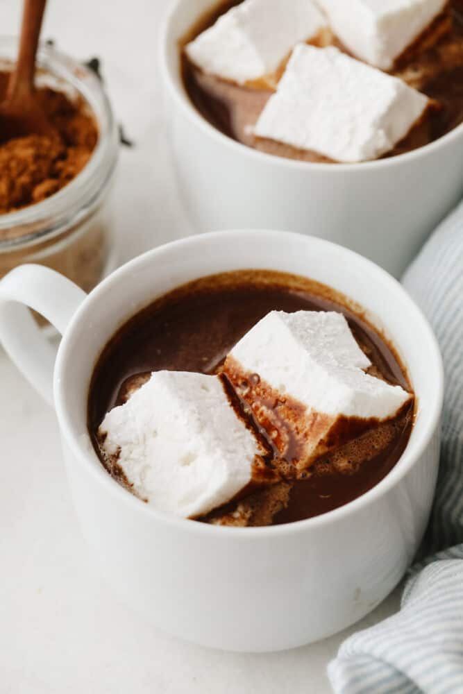 This easy homemade hot chocolate is the perfect treat to end your year with! It's so rich and creamy, you won't want it any other way! A cup of hot chocolate with 2 marshmallows on top.