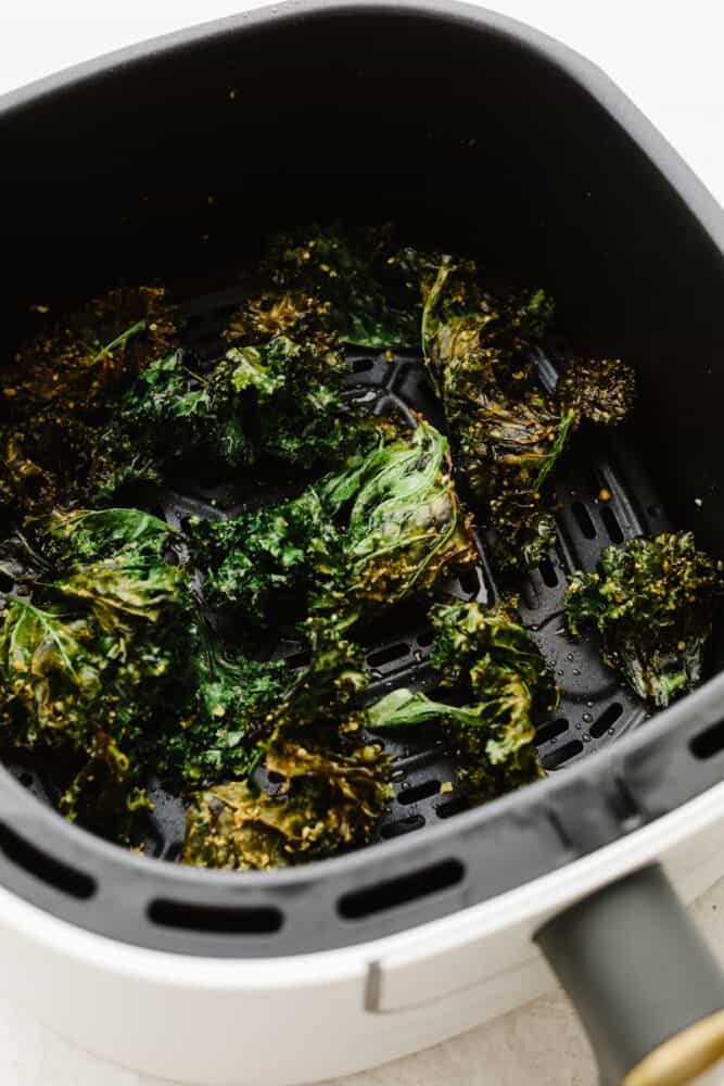 Crispy and seasoned perfectly with parmesan cheese, these kale chips that you cook in the air fryer are the BEST snack. They are quick and easy to make and I bet that you can't stop at just one! Kale chips in an air fryer.
