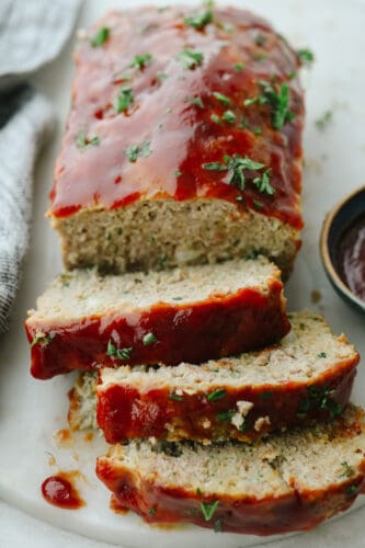 This tasty turkey meatloaf is light and lean but filled with so much flavor! Each bite is perfectly seasoned and tender, you'll love it! A turkey meatloaf with 3 slices cut.