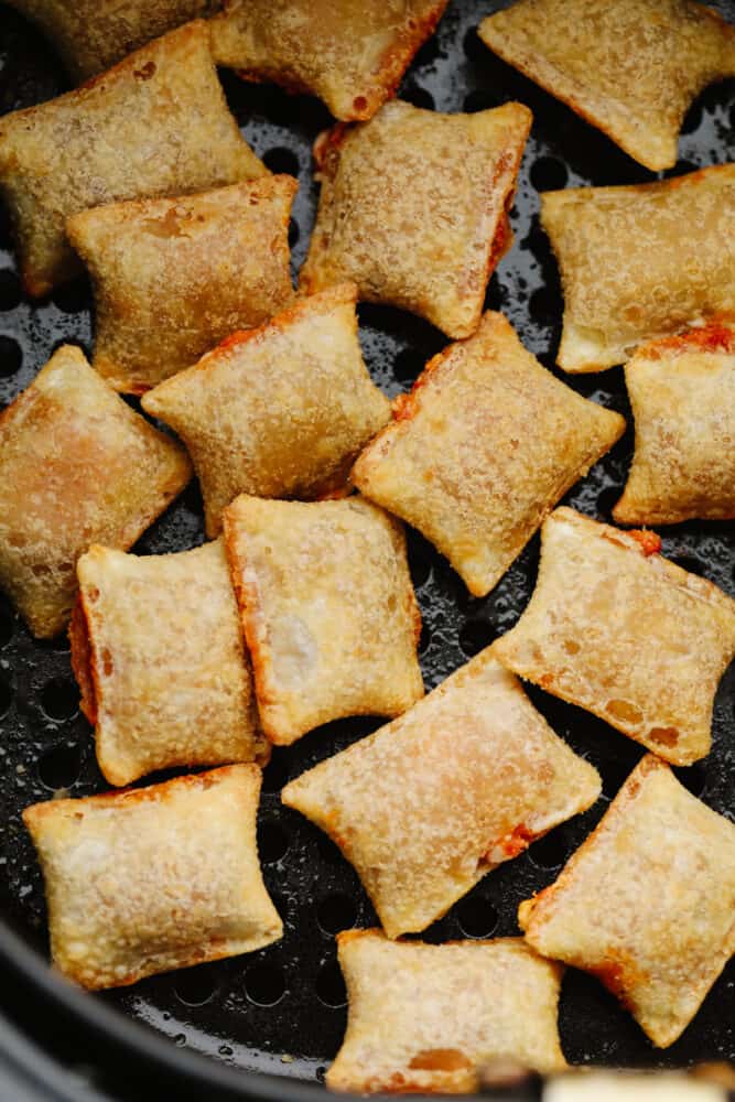 These pizza rolls are cooked to perfection in the air fryer. They take less than 10 minutes and make the perfect lunch or after-school snack. My kids love them! Pizza rolls in an air fryer basket.