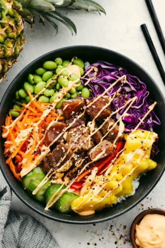 This Hawaiian poke bowl is fantastically fresh and full of healthy ingredients! Skip ordering this at a restaurant and make it at home in less than 15 minutes! A Hawaiian poke bowl with spicy aioli sauce on top.