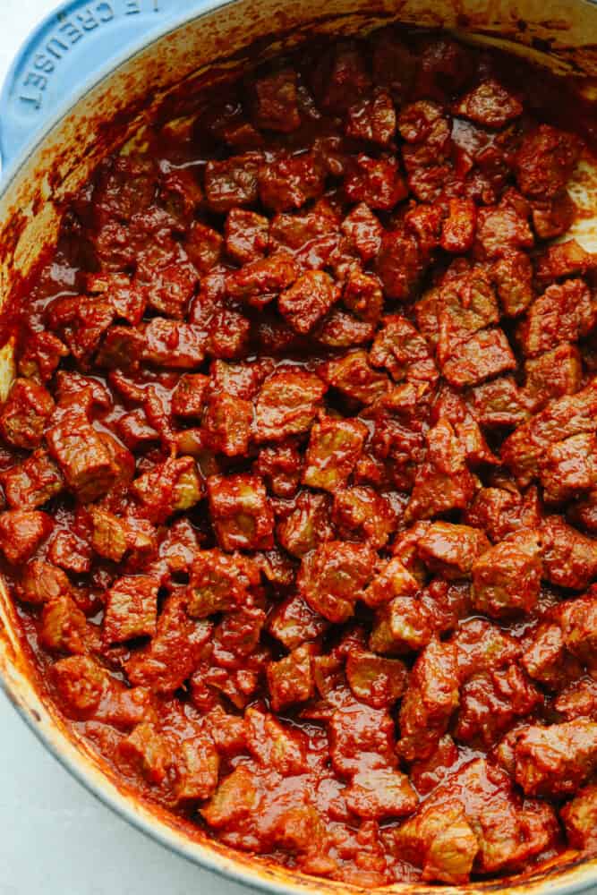 This pörkölt is a delicious Hungarian meat stew that is cooked in a savory onion sauce! It is simmered until it reaches juicy and tender perfection that will make it fall off your fork and melt in your mouth. A pot of cooked pörkölt.
