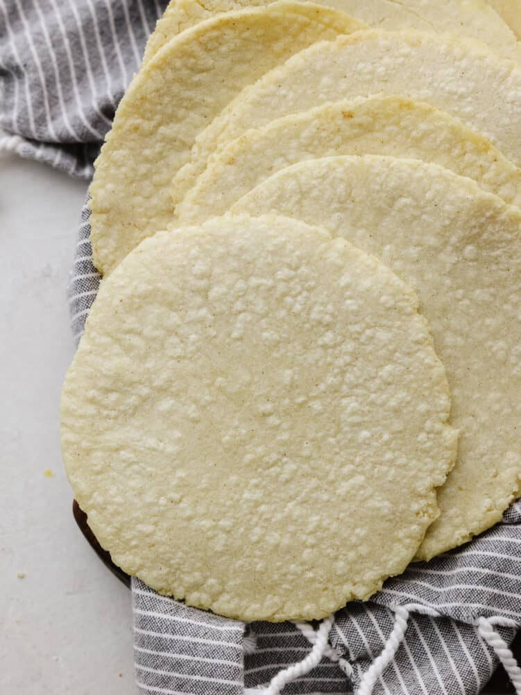 Homemade corn tortillas only have three ingredients and are a cinch to make! These guys are crispy on the edges, soft on the inside, and full of corn flavor. A stack of corn tortillas.