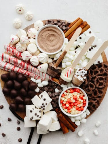 It doesn't get more fun than a hot chocolate charcuterie board! Filled with all of the delicious toppings and mix-ins that any hot chocolate lover will go crazy for, this board is for everyone! A round cutting board filled with hot chocolate toppings and mix-ins.