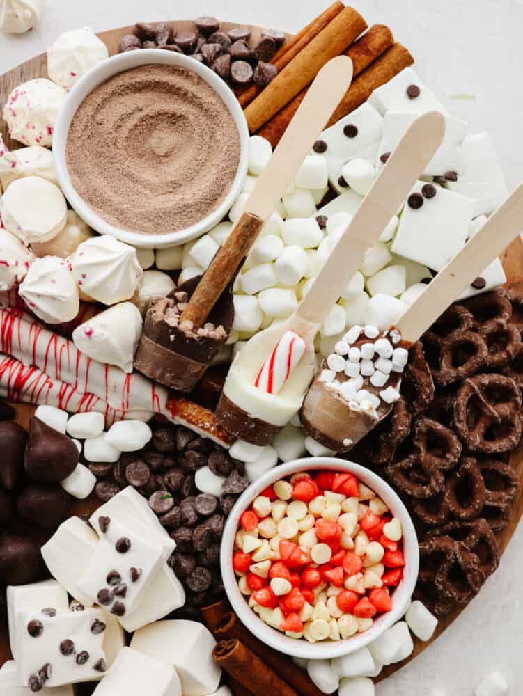 It doesn't get more fun than a hot chocolate charcuterie board! Filled with all of the delicious toppings and mix-ins that any hot chocolate lover will go crazy for, this board is for everyone! A hot chocolate charcuterie board with marshmallows, hot chocolate mix and chocolate treats.