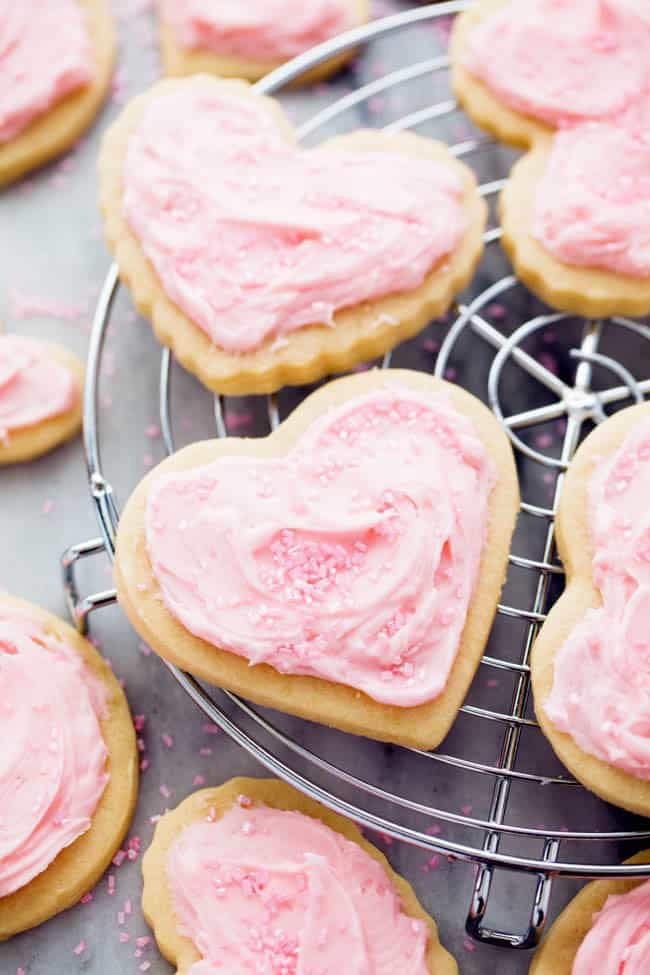 You cannot beat homemade sugar cookies with a crisp edge and a soft center. These are the BEST! Topped with my favorite cream cheese frosting and sprinkles, these sugar cookies are a tried and true favorite. Sugar Cookies on a cooling rack.