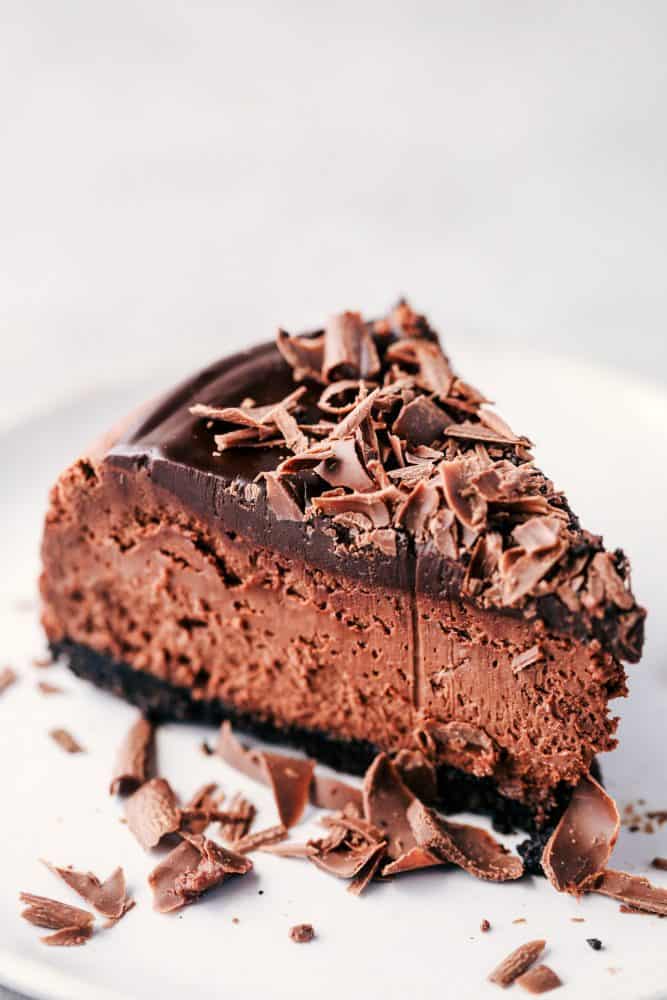 Death by chocolate cheesecake has an Oreo crust with creamy, decadent, and rich chocolate cheesecake. Topped with chocolate ganache, this is a chocolate lover's dream come true! A slice of Death By Chocolate Cheesecake.