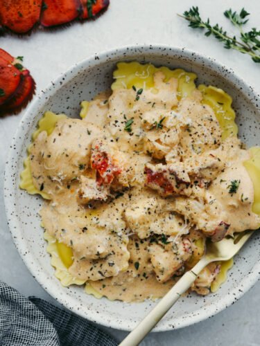 Lobster ravioli sauce is rich and creamy, full of fresh herbs and garlic! It's bursting with flavor and the perfect addition to all of your favorite pasta dishes. Lobster ravioli in a gray stoneware plate.
