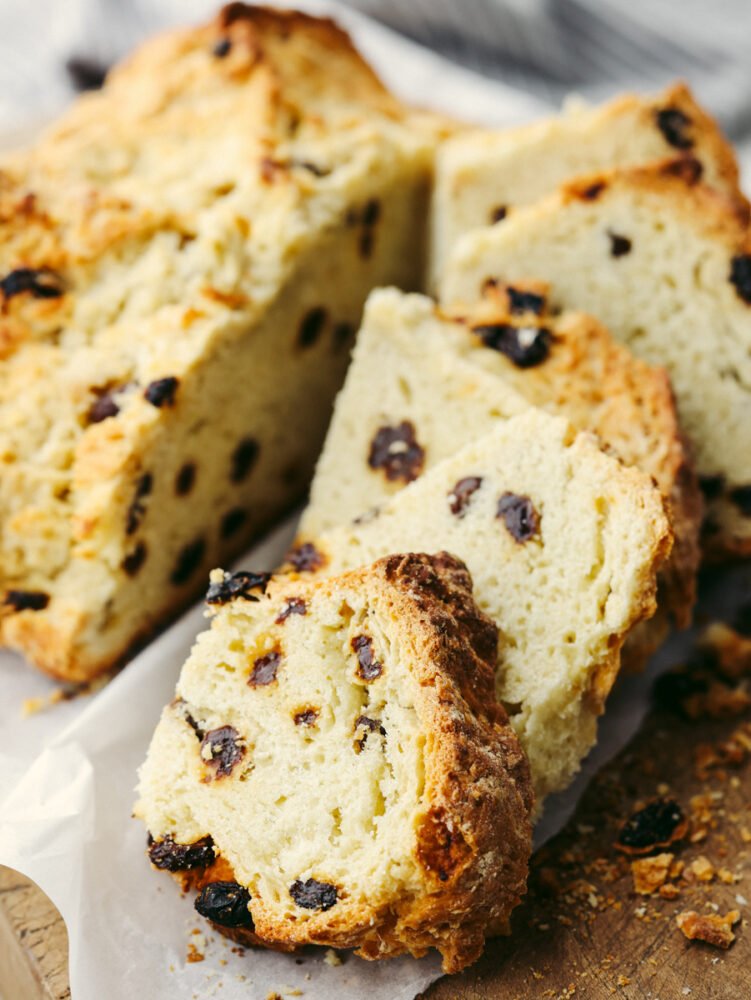 This traditional no yeast bread recipe is a crumbly dense bread with a slightly sweet taste. With only a few pantry and refrigerator staples required, this delicious traditional soda bread can be made easily and is one everyone will enjoy. A loaf of soda bread sliced and ready to eat.