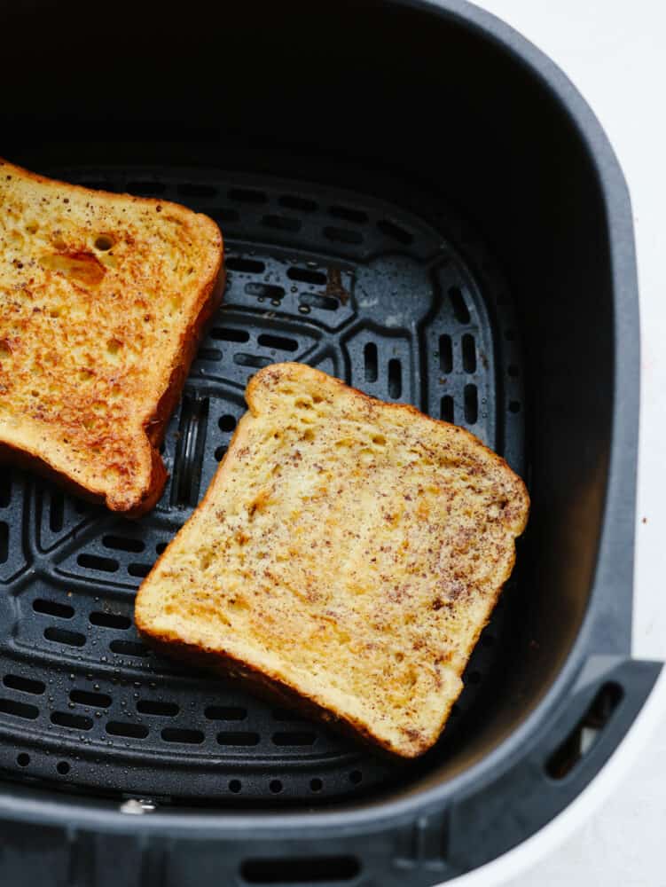 Air fryer french toast is simple and delicious! You can whip this up in less than 10 minutes, and your family will gobble it up so fast that it will fly off of your table! 2 pieces of cooked french toast in the air fryer.