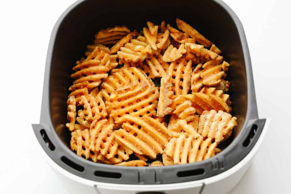 These air fryer frozen waffle fries are so easy and make the perfect side to any meal! Crispy and flavored to perfection, they will leave your mouth watering and wanting more! Frozen waffle fries in an air fryer basket.