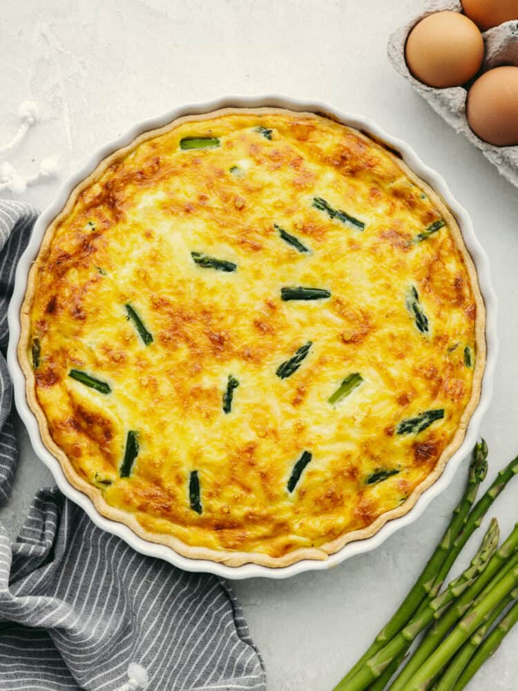 This asparagus quiche is as delicious as it is gorgeous! It has a perfectly flaky texture combined with an insanely delicious flavor. This will be the star of the show at any breakfast or brunch! The top view of a fully cooked asparagus quiche, ready to cut and serve.