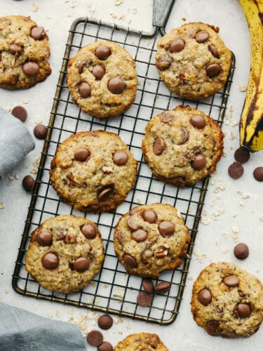 Banana oatmeal cookies with chocolate chips are the ultimate soft and nutty dessert. They're everything you love about banana bread and oatmeal cookies combined in one super easy treat! Top-down view of cookies on a cooling rack.