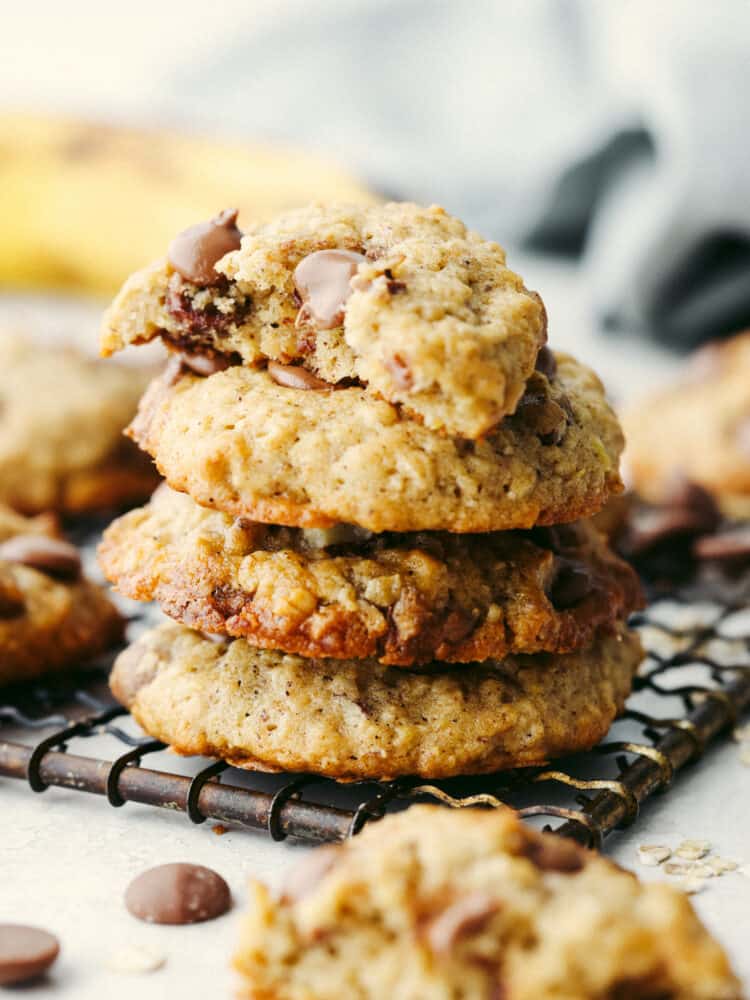 Banana oatmeal cookies with chocolate chips are the ultimate soft and nutty dessert. They're everything you love about banana bread and oatmeal cookies combined in one super easy treat! A stack of 4 cookies, one with a bite taken out of it.