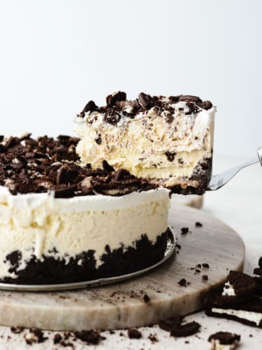 Ice cream cake is the best of both worlds...ice cream in the form of a cake! This cookies and cream ice cream cake is exploding with layers of oreo cookies, ice cream, and gooey fudge sauce. The sside view of an ice cream cake with a slice being taken out so that you can see the inside.