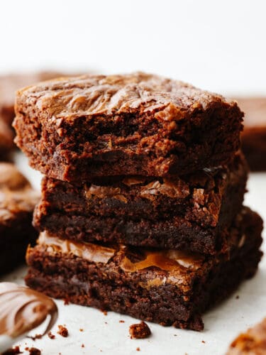 This super easy 3-ingredient brownie recipe is the only one you'll ever need! These brownies are rich and fudgy, the perfect solution for when you're craving chocolate! A stack of 3 brownies, one with a bite taken out of it.