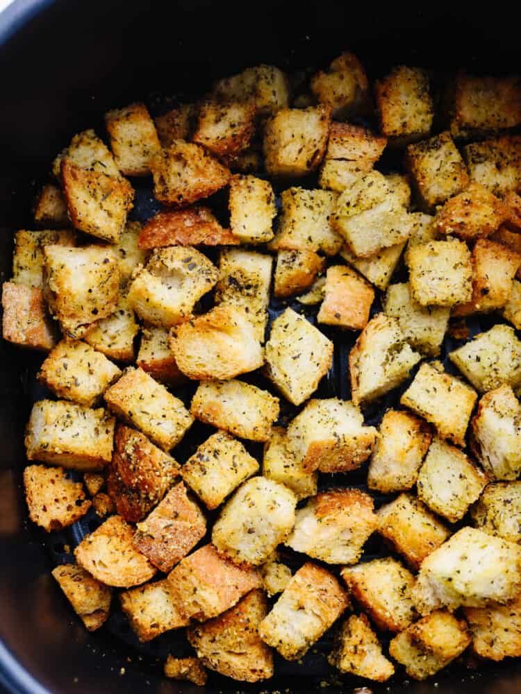 These quick and easy air fryer croutons will give your salads and recipes that "wow" factor! A fresh loaf of bread cubed, seasoned, and air fried to perfection. Closeup of croutons in air fryer basket.