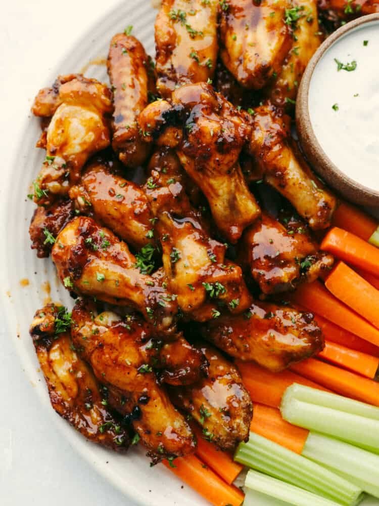 Making your frozen chicken wings in the air fryer is the only method to use, no thawing required! Along with this easy-to-make honey buffalo sauce, you'll never want them any other way! Top-down view of chicken wings served with dipping sauce and fresh vegetables.