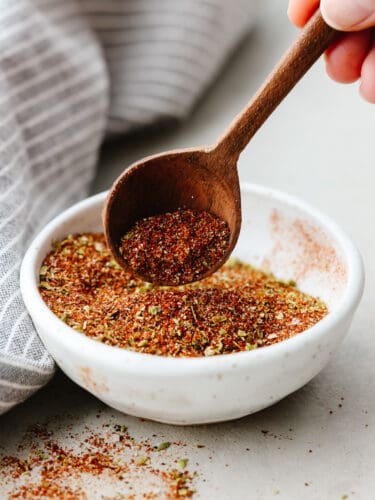 This homemade chili seasoning is filled with all the best herbs and spices to elevate your meal! Once you make your own delicious blend, you won't want storebought again! Herbs and spices mixed together to make chili seasoning in a small white bowl.
