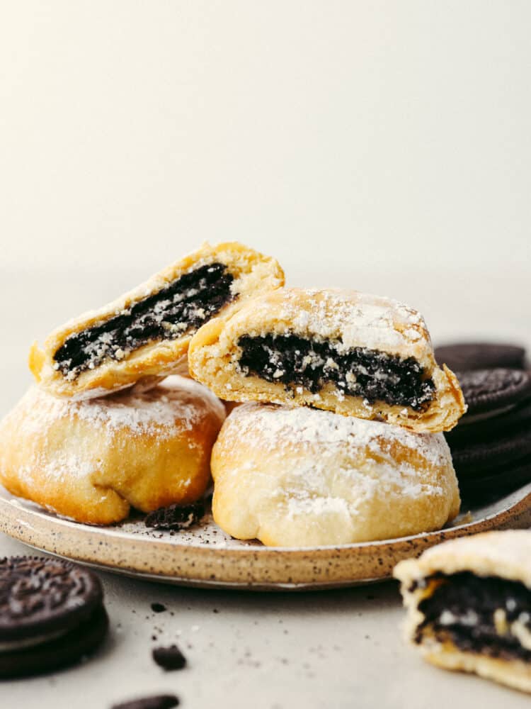 Get all the deliciousness of deep-fried Oreos without the mess or calories in this quick and easy air fryer Oreos recipe! It only takes 3 ingredients to make them and they’ll have the whole family hooked! A stack of 4 fried Oreos, 2 of which are split in half so the Oreo filling can be seen.