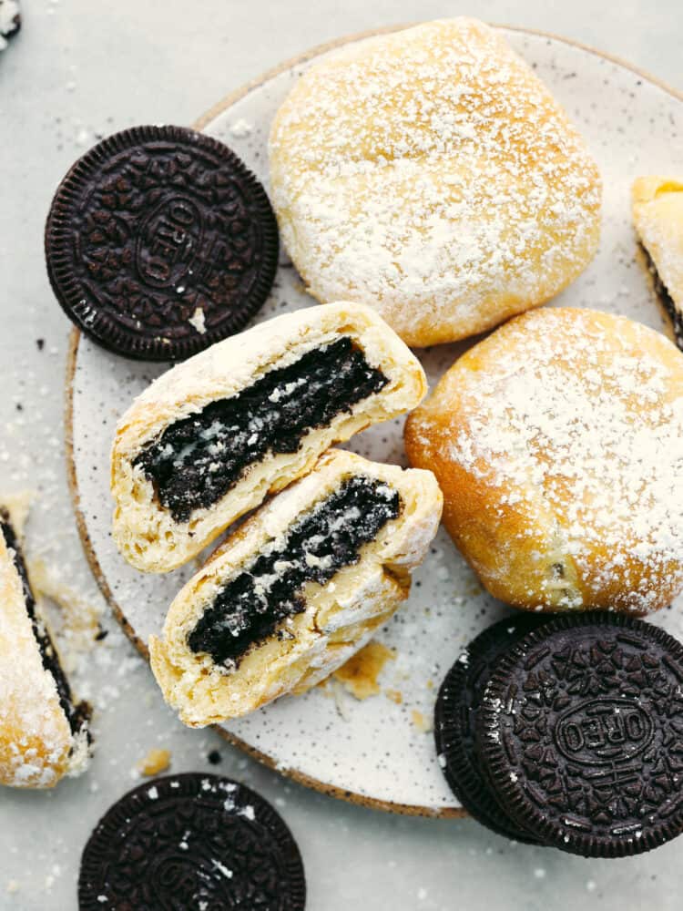 Get all the deliciousness of deep-fried Oreos without the mess or calories in this quick and easy air fryer Oreos recipe! It only takes 3 ingredients to make them and they’ll have the whole family hooked! Top-down view of fried Oreos on a stoneware plate.