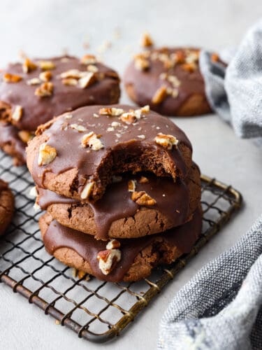 These fudgy, ooey-gooey Texas sheet cake cookies are every chocolate lover's dream! They are supremely moist and made with super simple ingredients for an anytime treat! A stack of 3 cookies on a cooling rack.