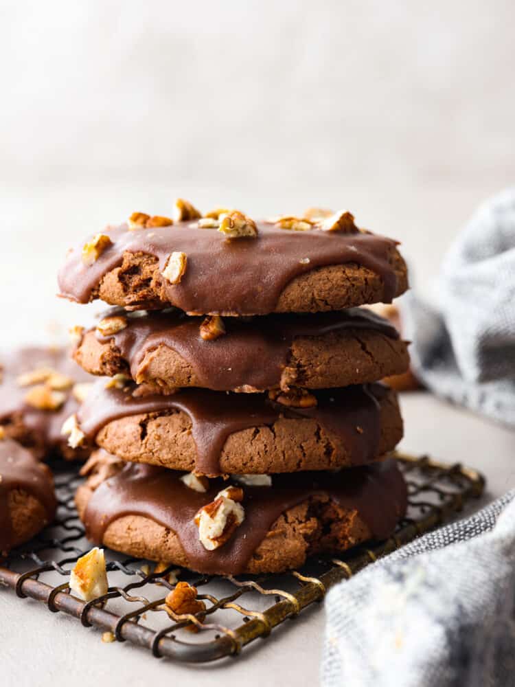 These fudgy, ooey-gooey Texas sheet cake cookies are every chocolate lover's dream! They are supremely moist and made with super simple ingredients for an anytime treat! 4 cookies stacked on top of each other.